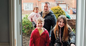 A family walking in the front door of their house