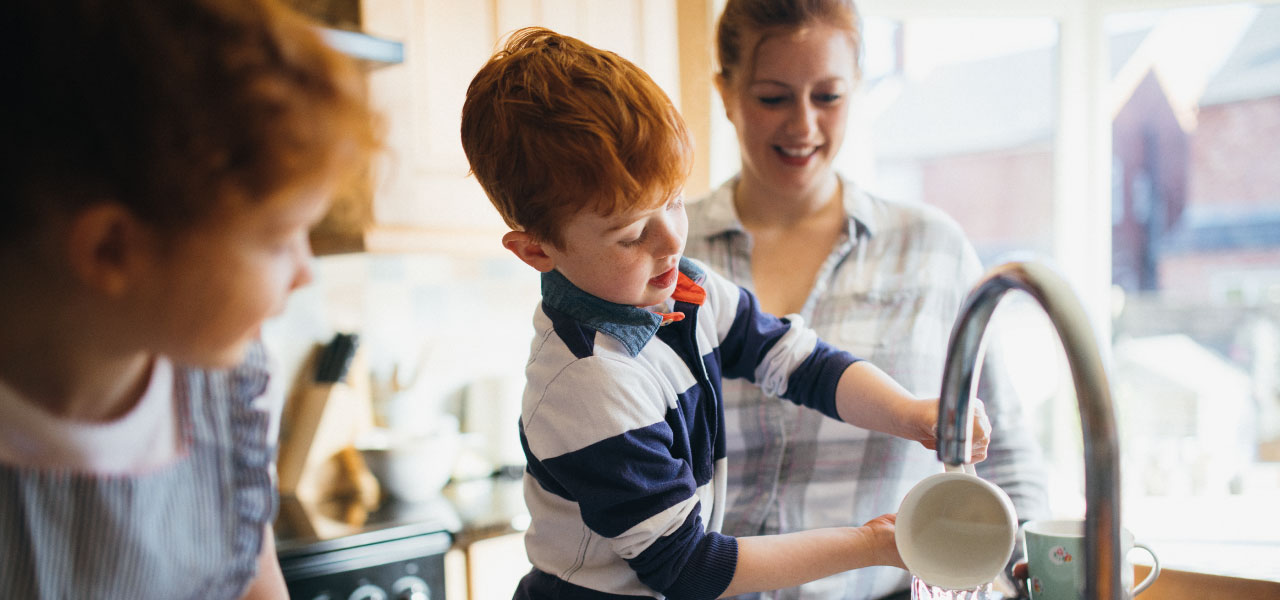 A family washing up at the sink together